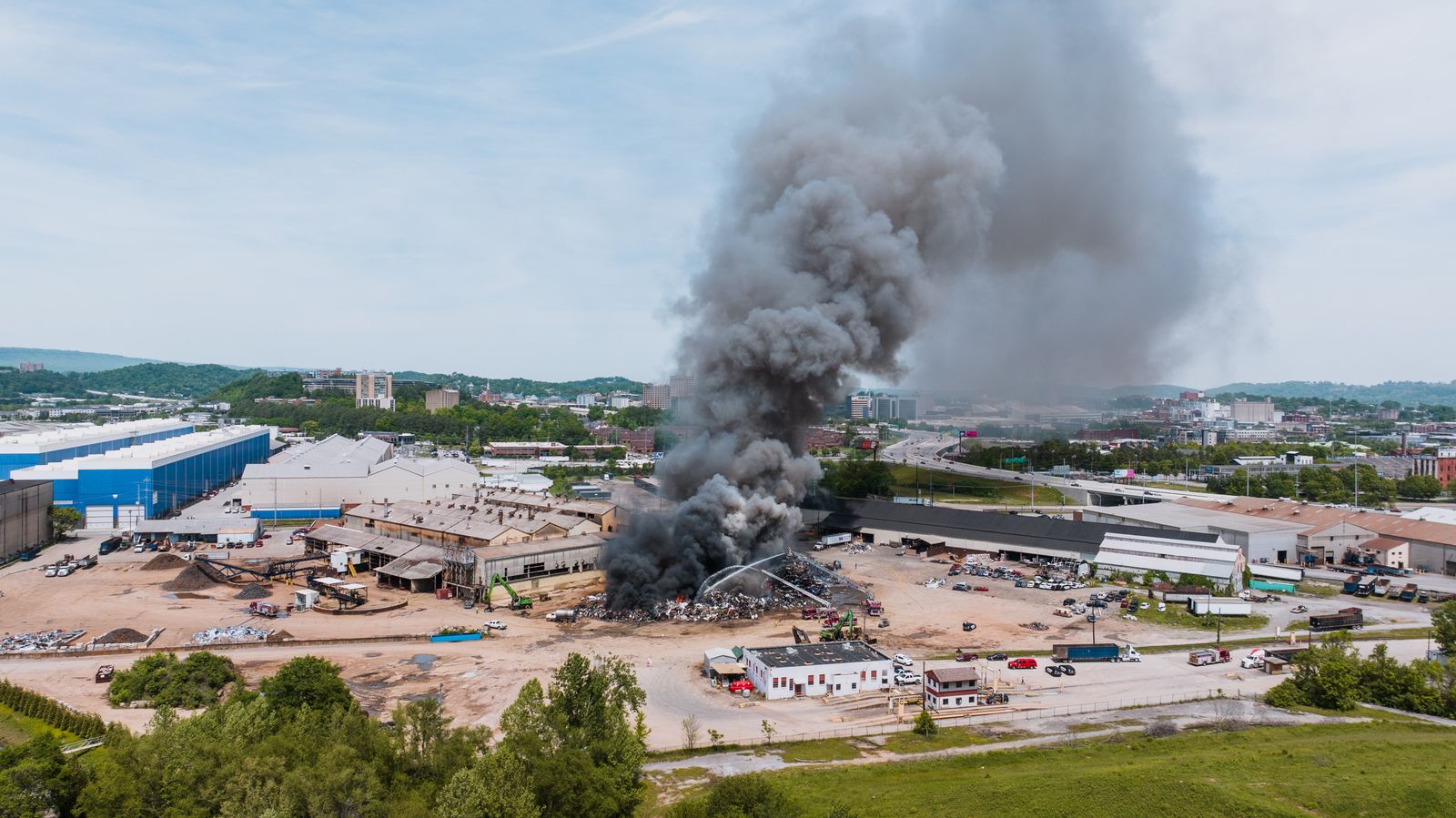 Fumée noire s'élevant d'un site industriel en feu, vue aérienne de jour