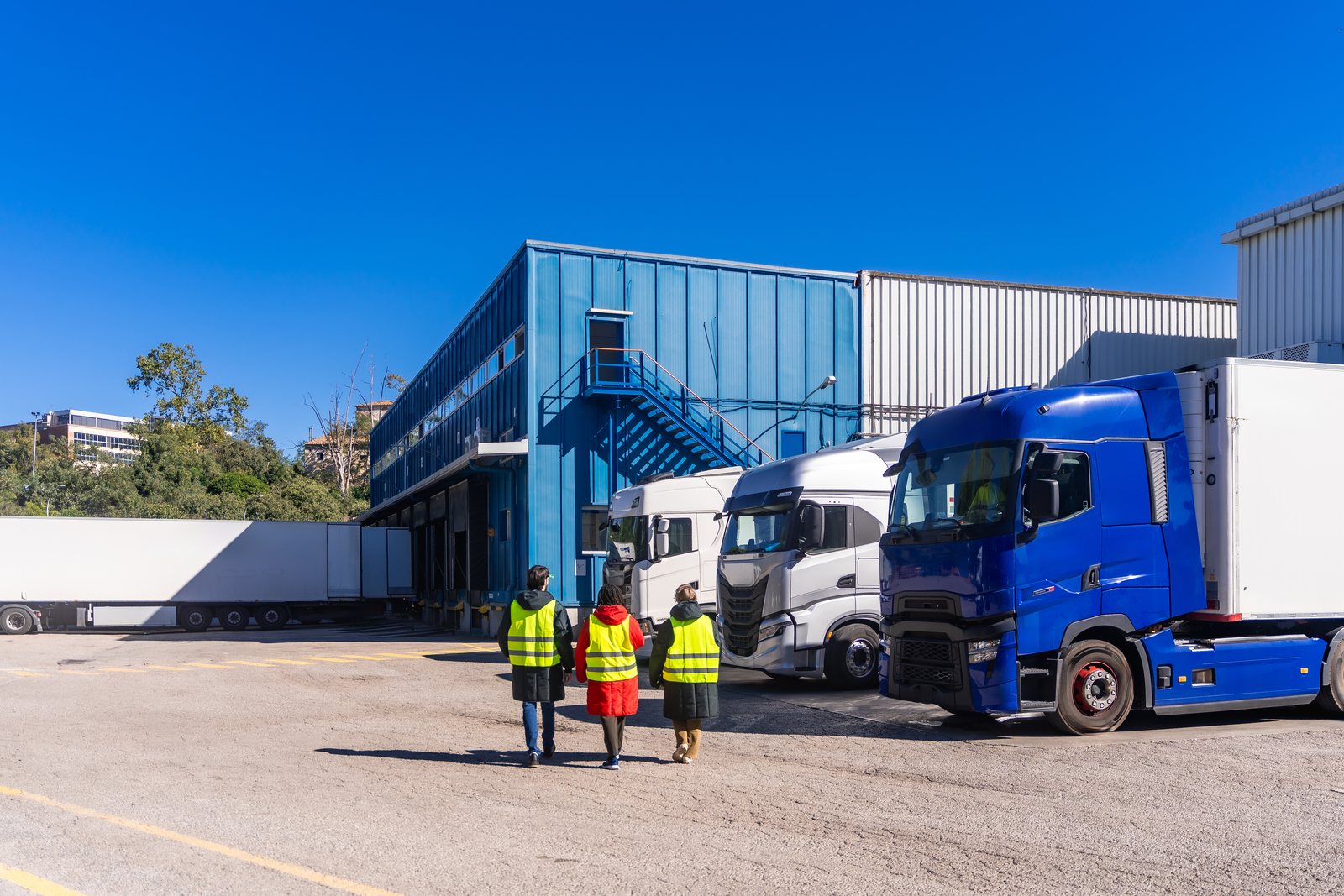 Opérateurs logistiques devant un entrepôt frigorifique